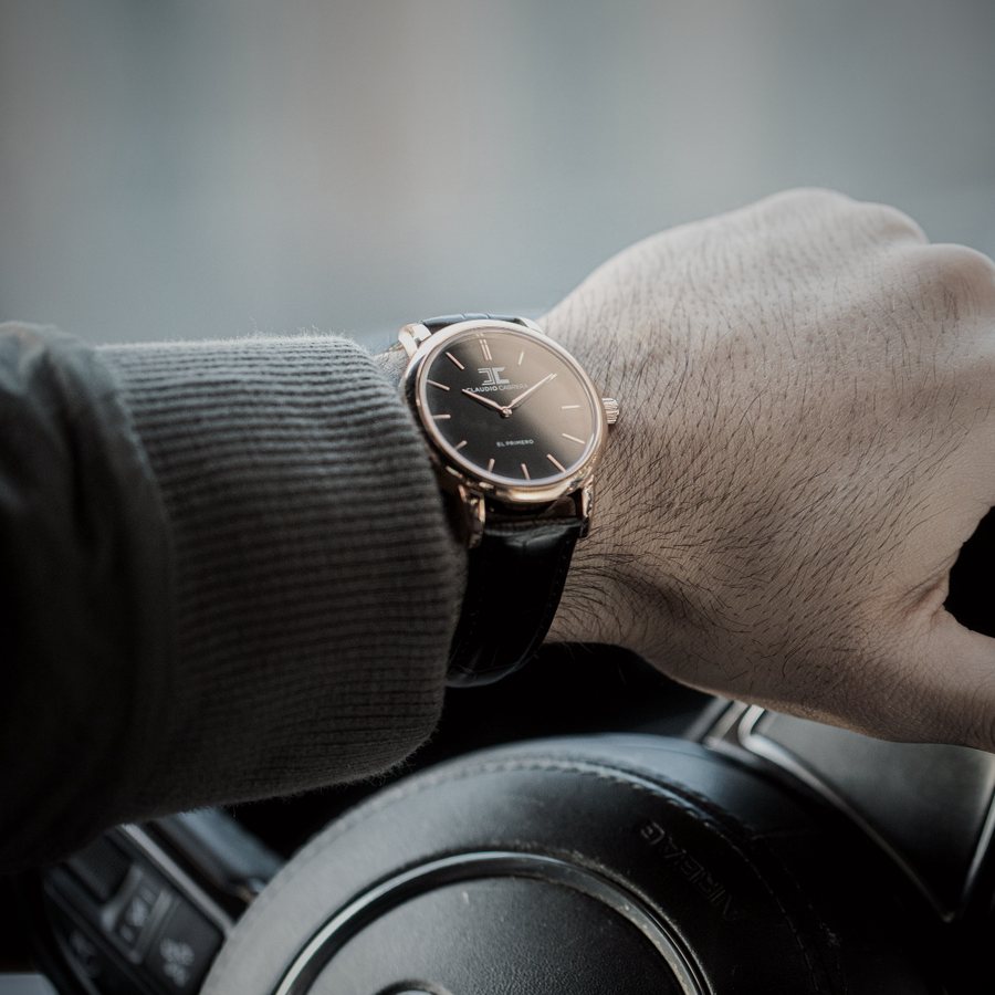 Watch on the wrist of a driver holding the steering wheel